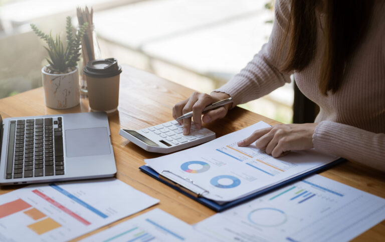 Businesswoman sitting planning analyze investment and marketing on the desk in the office.